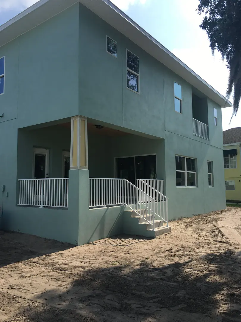 A green gray building with white handrailings